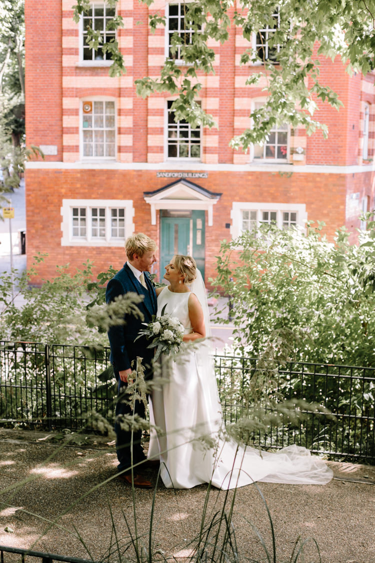 London City Bride Groom Buildings Street Foliage Greenery White Bouquet Jesus Peiro Dress Navy Suit | Modern Tropical Gold Urban Wedding https://www.christinewehrmeier.com/