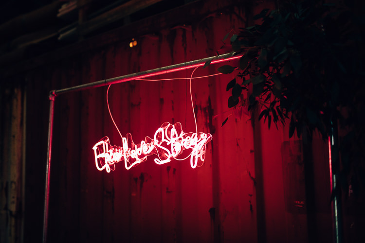 Ceremony Room Neon Sign Backdrop Metal Frame Foliage Edgy Raw Industrial Barn Wedding Ideas Greenery Festoon Lights http://www.two-d.co.uk/