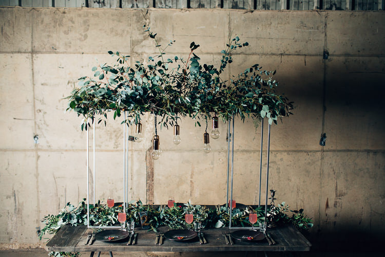 Table Tablescape Flowers Black Plates Calligraphy Swag Garland Suspended Hanging Edgy Raw Industrial Barn Wedding Ideas Greenery Festoon Lights http://www.two-d.co.uk/