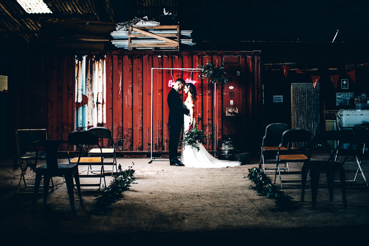 Ceremony Room Neon Sign Backdrop Metal Frame Foliage Edgy Raw Industrial Barn Wedding Ideas Greenery Festoon Lights http://www.two-d.co.uk/