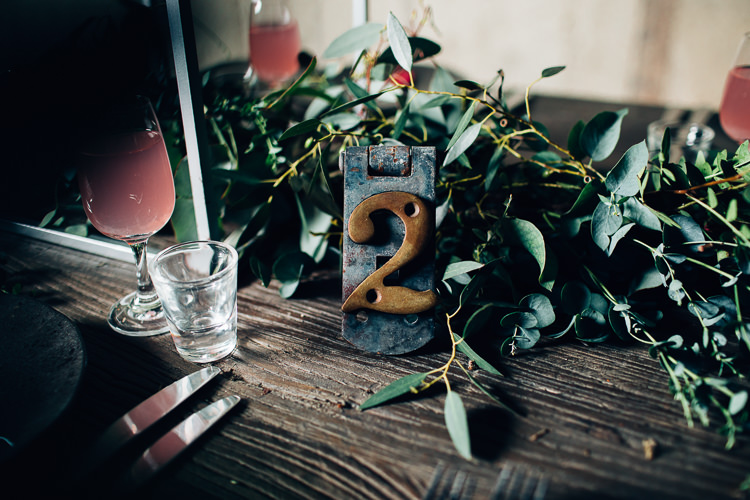 Table Names Edgy Raw Industrial Barn Wedding Ideas Greenery Festoon Lights http://www.two-d.co.uk/