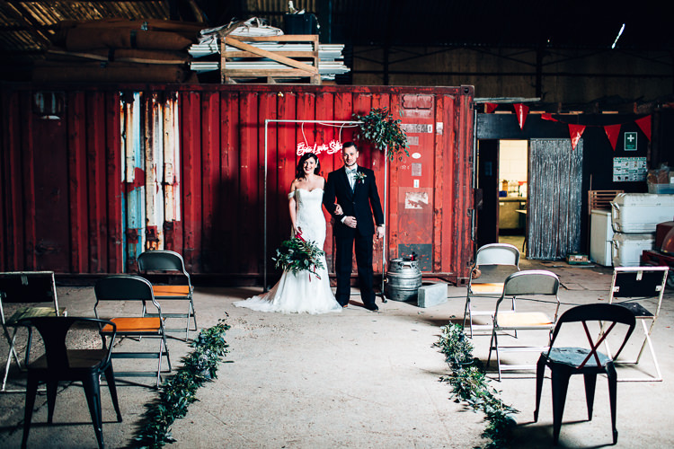 Ceremony Room Neon Sign Backdrop Metal Frame Foliage Edgy Raw Industrial Barn Wedding Ideas Greenery Festoon Lights http://www.two-d.co.uk/