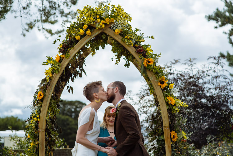 DIY Ceremony Bride Groom Kiss Yellow Wildflower Floral Arch Seasonal Alternative Hippy Farm Field Garden Wedding | Homegrown Community Eclectic Rural Yorkshire Wedding https://toastofleeds.co.uk/