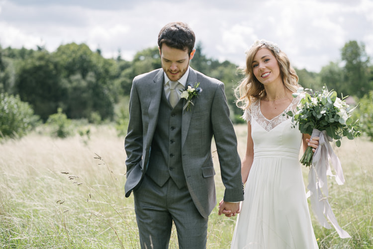 Bride Bridal Rembo Styling Lace V Neck Dress Gown Hairpiece White Cream Rose Bouquet Eucalyptus Greenery Groom Groomsman Three Piece Grey Suit Relaxed Bohemian Summer Meadow Wedding https://karibellamy.com/