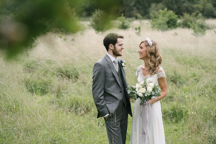 Bride Bridal Rembo Styling Lace V Neck Dress Gown Hairpiece White Cream Rose Bouquet Eucalyptus Greenery Groom Groomsman Three Piece Grey Suit Relaxed Bohemian Summer Meadow Wedding https://karibellamy.com/