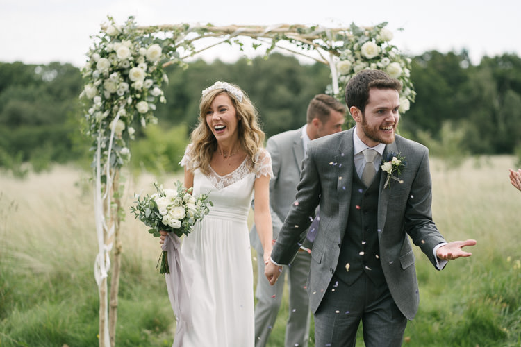 Bride Bridal Rembo Styling Lace V Neck Dress Gown Hairpiece White Cream Rose Bouquet Eucalyptus Greenery Groom Groomsman Three Piece Grey Suit Confetti Relaxed Bohemian Summer Meadow Wedding https://karibellamy.com/