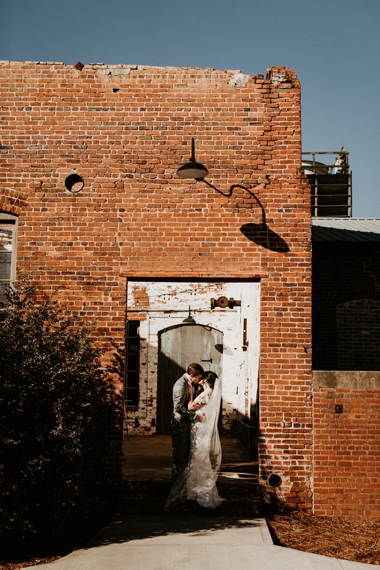 City Urban Georgia Engine Room Exposed Bricks Bride Groom Embrace First Look | Bohemian Industrial Oxblood Wedding https://www.lunaleephotos.com/