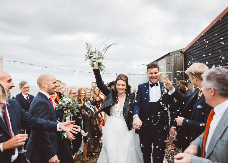 Bride Bridal Hayley Paige Dress Gown Tulle Princess Tuxedo Groom Waistcoat Navy Bow Tie Bouquet Ribbon Leather Jacket Confetti Shot Cool Stylish Windy Coastal Wedding East Quay Lobster Shack Whitstable http://holliecarlinphotography.com/