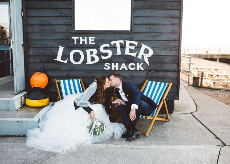 Bride Bridal Hayley Paige Dress Gown Tulle Princess Tuxedo Groom Waistcoat Navy Bow Tie Bouquet Ribbon Leather Jacket Deck Chairs Cool Stylish Windy Coastal Wedding East Quay Lobster Shack Whitstable http://holliecarlinphotography.com/