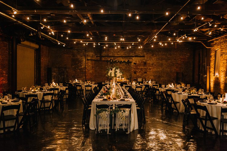 Warehouse Modern Refined Rustic Chic Festoon Lighting Black Chairs White Flowers | Boho Industrial Winter Wedding Lunalee Photography