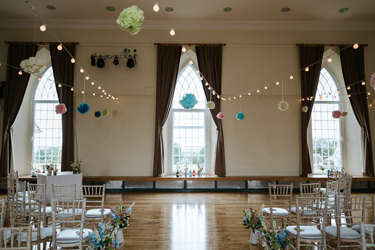 Ceremony Room Festoon Lights Pompoms Pretty Pastel Floral Village Hall Wedding Struve Photography