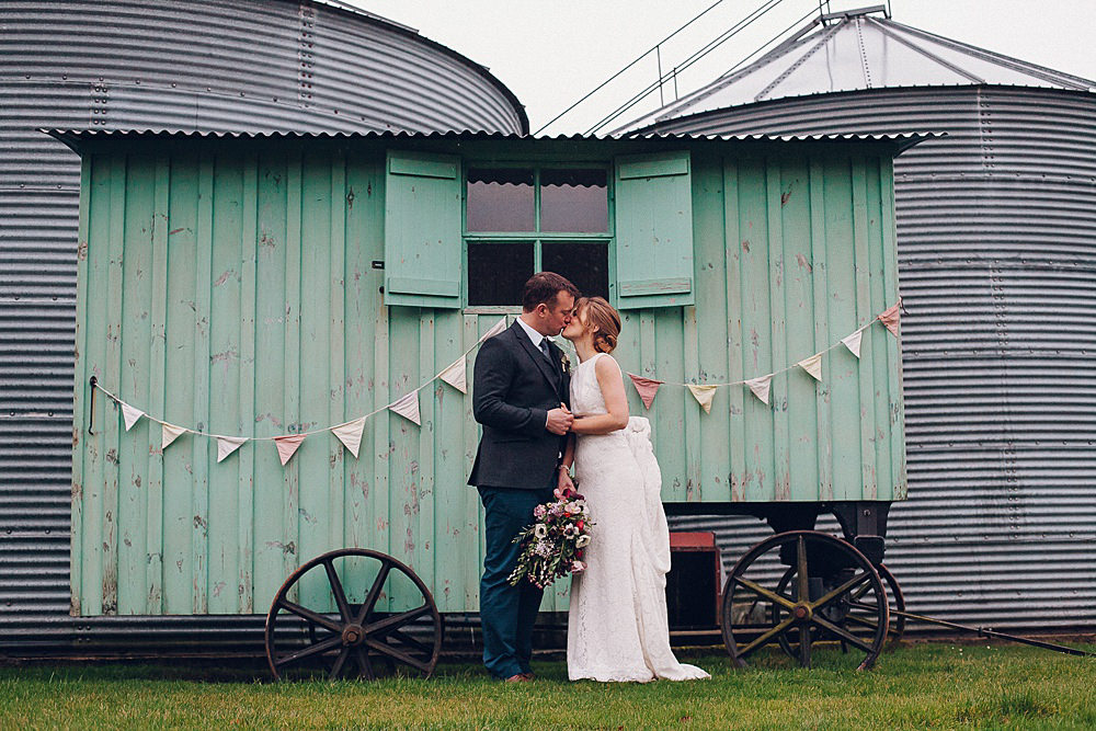 Bride Bridal Lace Boat Neck Cut Out Back Pronovias Dress Tweed Groom Bouquet Anemone Shepherds Hut Bunting Merriscourt Barn Wedding Cotswolds Katie de Silva Photography