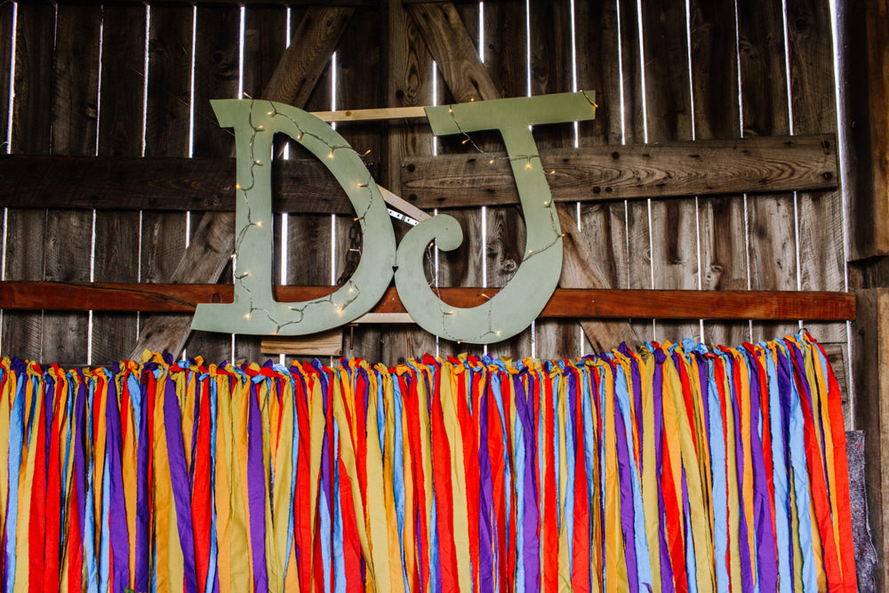 Initials Fairy Lights Coloured Streamers Backdrop Decor Secret Barn Sussex Wedding Rainbow Colourful Yvonne Lishman Photography