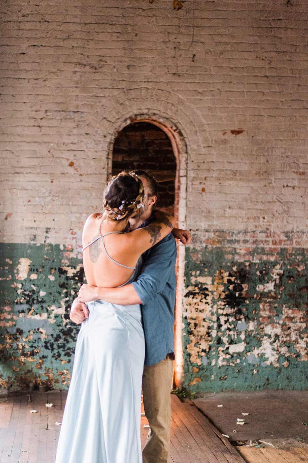 Nature Inspired Styled Shoot Seashell Headpiece Updo Tattooed Bride Blue Dress Casual Groom Blue Shirt Kiss | Ocean Wedding Ideas Industrial Rachel Watkinson Photography