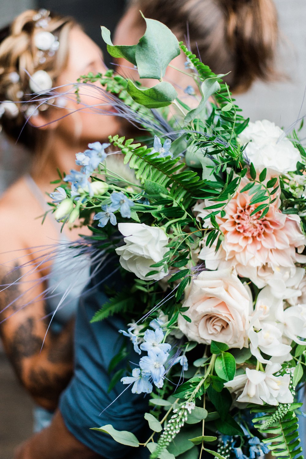 Nature Inspired Styled Shoot Seashell Headpiece Updo Tattooed Bride Blue Dress Casual Groom Blue Shirt Pastel Bouquet Kiss | Ocean Wedding Ideas Industrial Rachel Watkinson Photography