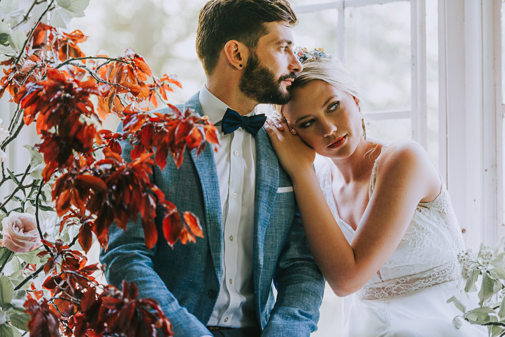 Secret Dresshouse Ethereal Bride Bridal Gown Blue Linen Jacket Bow Tie Groom Leaf Foliage Flower Florals River Romance Wedding Ideas Mindy Coe Photography