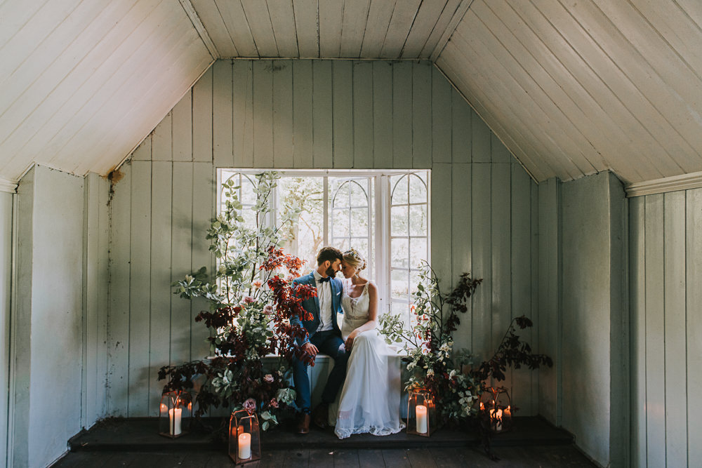 Secret Dresshouse Ethereal Bride Bridal Gown Blue Linen Jacket Bow Tie Groom Leaf Foliage Flower Florals Storm Hurricane Lanterns Candles River Romance Wedding Ideas Mindy Coe Photography