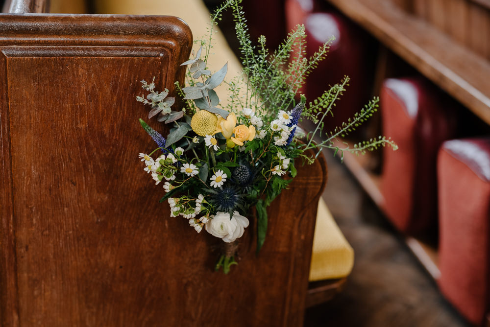 Outdoor Farm Field Marquee Yellow Blue Green Wildflowers Church Pew Decoration Ceremony | Rustic and Relaxed Spring Tipi Wedding Inbetween Days Photography