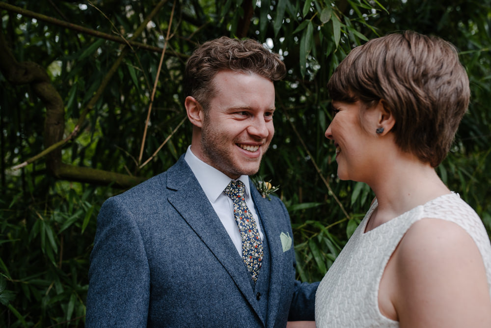 Outdoor Farm Field Marquee Groom Bride Pixie Cut Blue Suit Modern Green Yellow Buttonhole | Rustic and Relaxed Spring Tipi Wedding Inbetween Days Photography