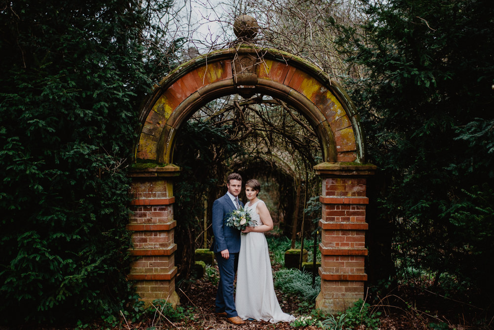 Outdoor Farm Field Marquee Groom Bride Arch Blue Suit Modern Green Yellow Bouquet | Rustic and Relaxed Spring Tipi Wedding Inbetween Days Photography