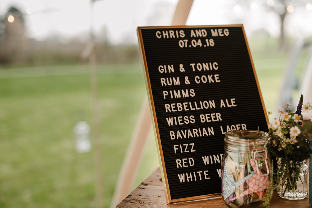 Outdoor Farm Field Marquee Open Bar Black Pinboard Sign Daisies | Rustic and Relaxed Spring Tipi Wedding Inbetween Days Photography