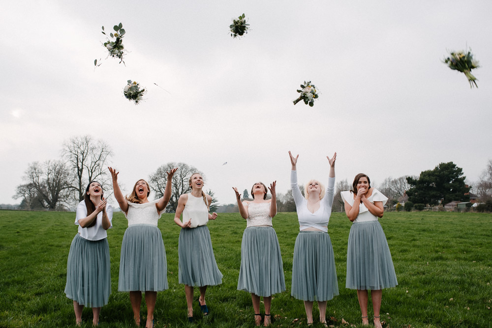 Outdoor Farm Field Marquee Bridesmaids White Grey Separates Group Bouquet Toss | Rustic and Relaxed Spring Tipi Wedding Inbetween Days Photography