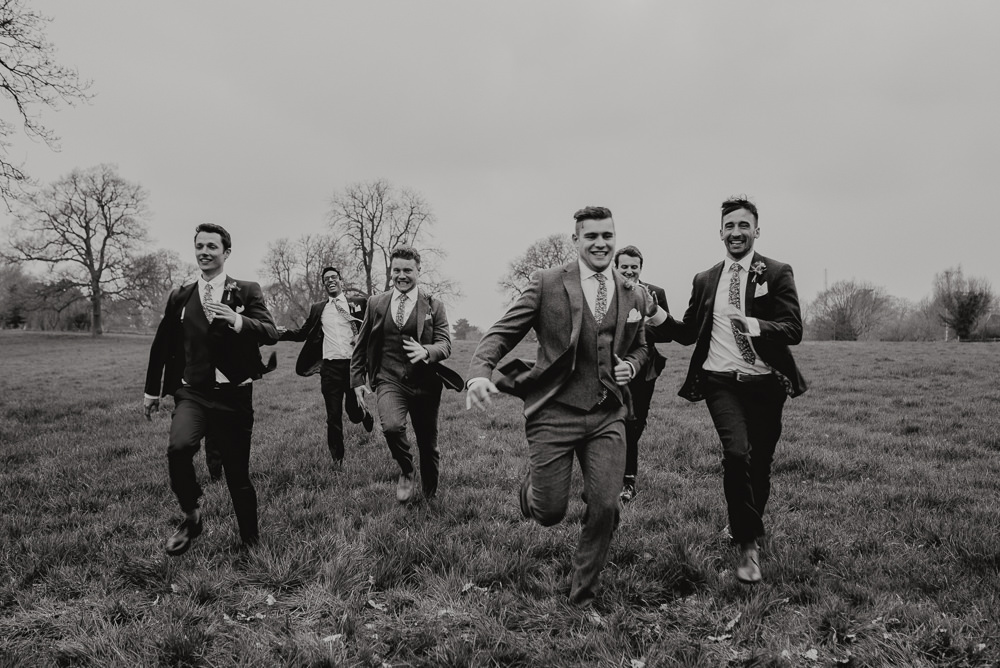 Outdoor Farm Field Marquee Groom Groomsmen Blue Navy Suits Funny Running | Relaxed and Rustic Spring Tipi Wedding Inbetween Days Photography