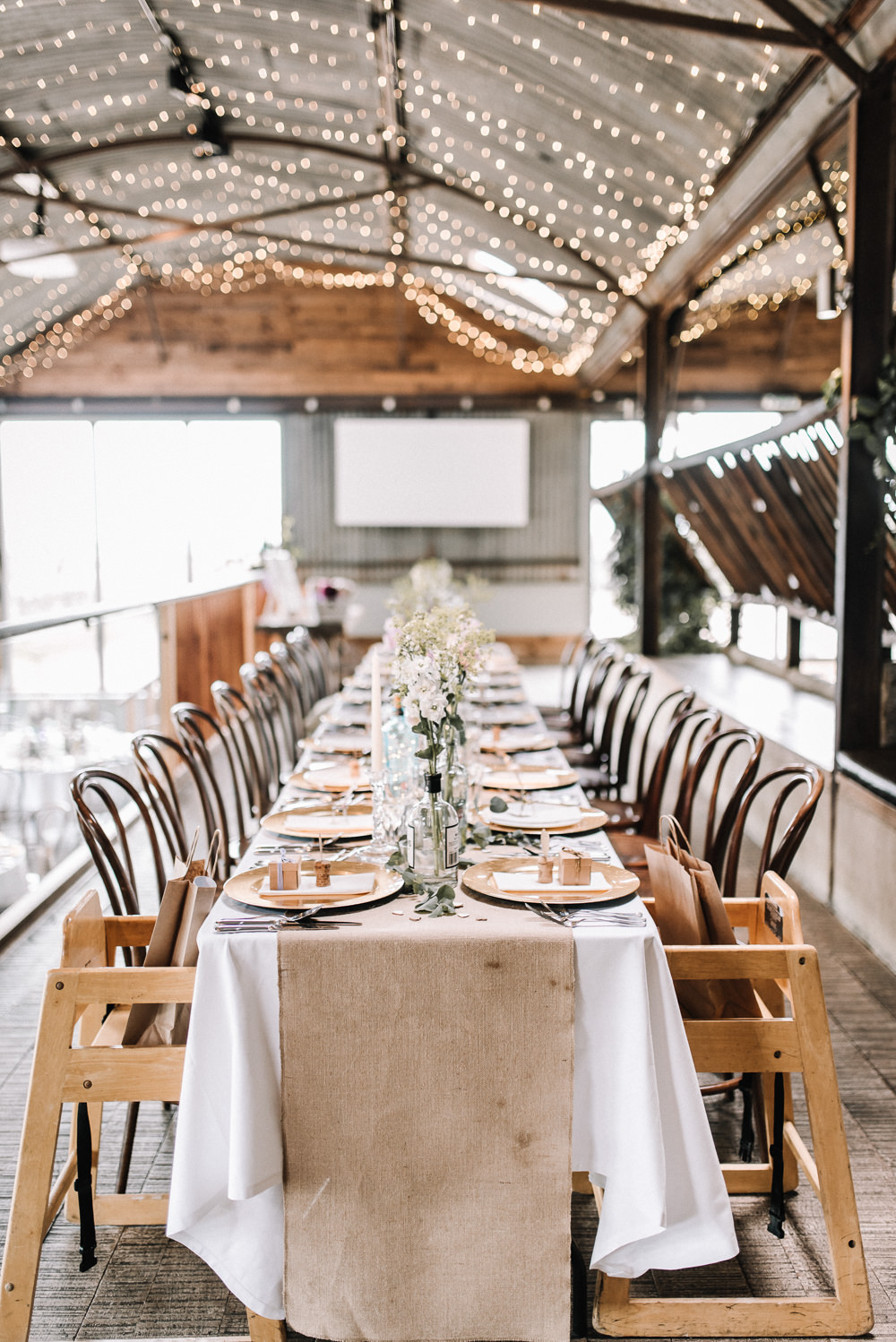 Gin Bottle Flowers Table Pretty Pink Greenery Decor Fairy Lights Hessian Stone Barn Wedding Oobaloos Photography