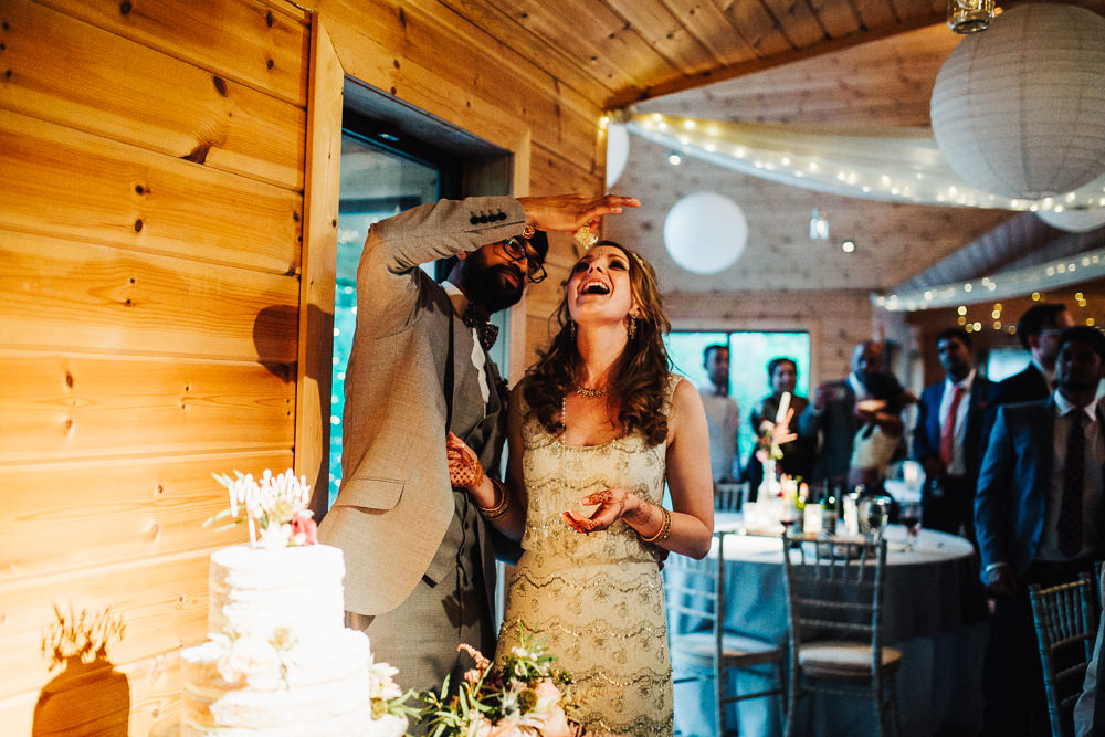 Styal Lodge Multicultural English Bride Groom Cake Cutting Feeding Funny | Modern and Colorful Indian Wedding Emilie May Photography