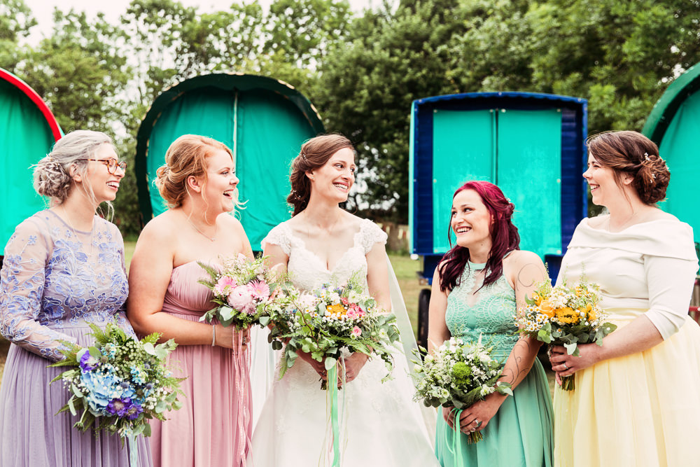 Bride Bridal Bespoke Dress Cape Sweetheart Neckline A Line Lace Bridesmaids Purple Pink Green Yellow Wildflower Meadow Bouquet Festival Wedding Mismatched Country Camilla Lucinda Photography