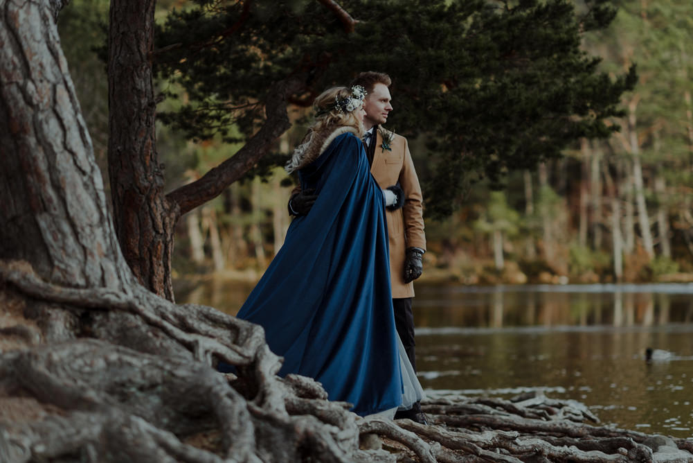 Forest Trees Castle Loch Bride Groom Blue Dress White Bouquet Floral Crown Cape Tan Coat | Intimate Winter Outdoor Scotland Wedding Christopher Ian Photography