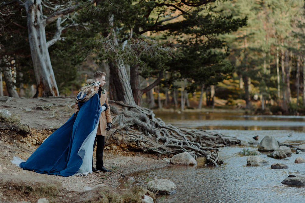 Forest Trees Castle Loch Bride Groom Blue Dress White Bouquet Floral Crown Cape Tan Coat | Intimate Winter Outdoor Scotland Wedding Christopher Ian Photography