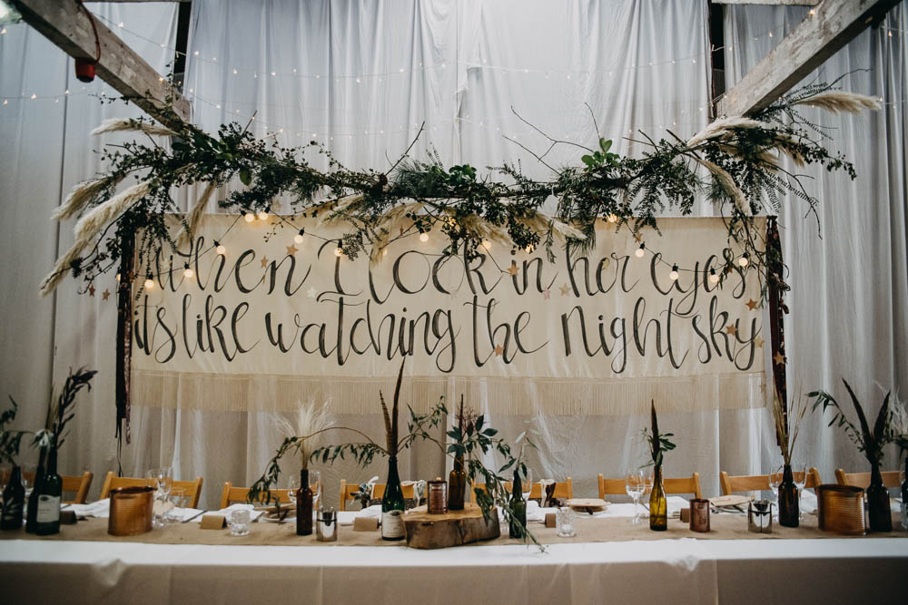 Top Table Back Drop Greenery Pampas Grass Brush Lettering Feathers Bottles Wood Tree Slice Railway Barn Wedding Lottie Photography
