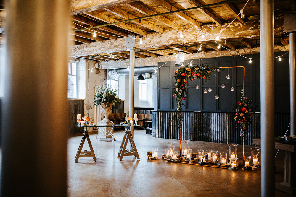 Ceremony Warehouse Industrial Festoon Lights Flowers Backdrop Arch Aisle Holmes Mill Wedding Emilie May Photography