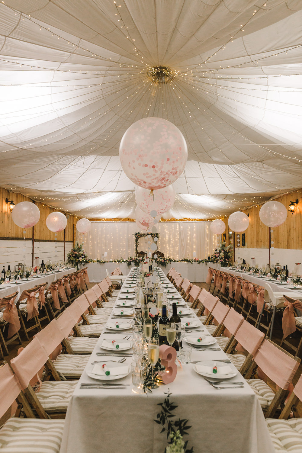 Reception Venue Room Drapes Fairy Lights Ceiling Flowers Aisle Arch Floral Pink Greenery Giant Balloons Wellbeing Farm Wedding Anna Wood Photography