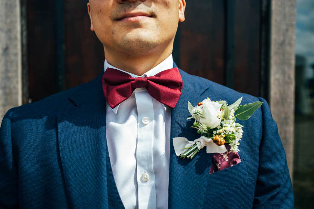 Groom Groomsmen Blue Suits Burgundy Bow Ties Buttonhole Flowers Berry Rose Thistle Long Barn Wedding Three Flowers Photography