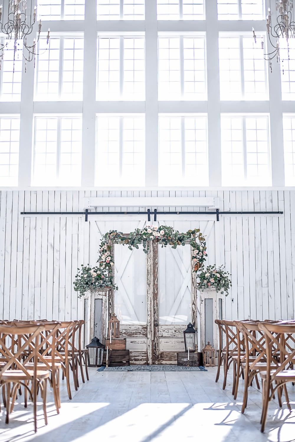 Ceremony Wooden Cross Back Chairs Foliage Floral Archway Storm Lanterns White Sparrow Barn Wedding White Blue Ideas Si Creative Photography