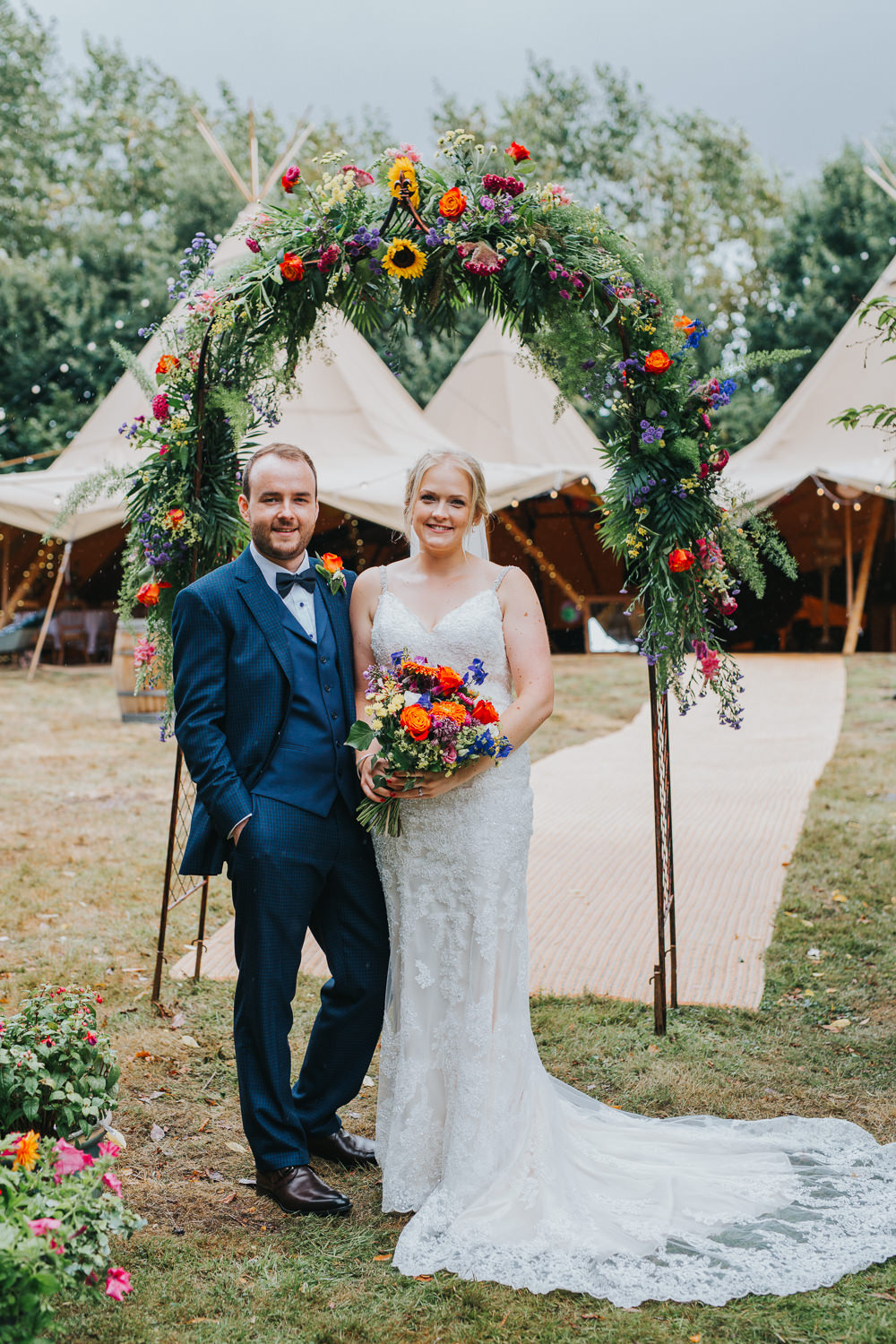 Mori Lee Dress Gown Bride Bridal Train Lace Flower Arch Backdrop Greenery Foliage Flowers Sunflowers Rose Colourful Tipi Wedding Charlotte Razzell Photography