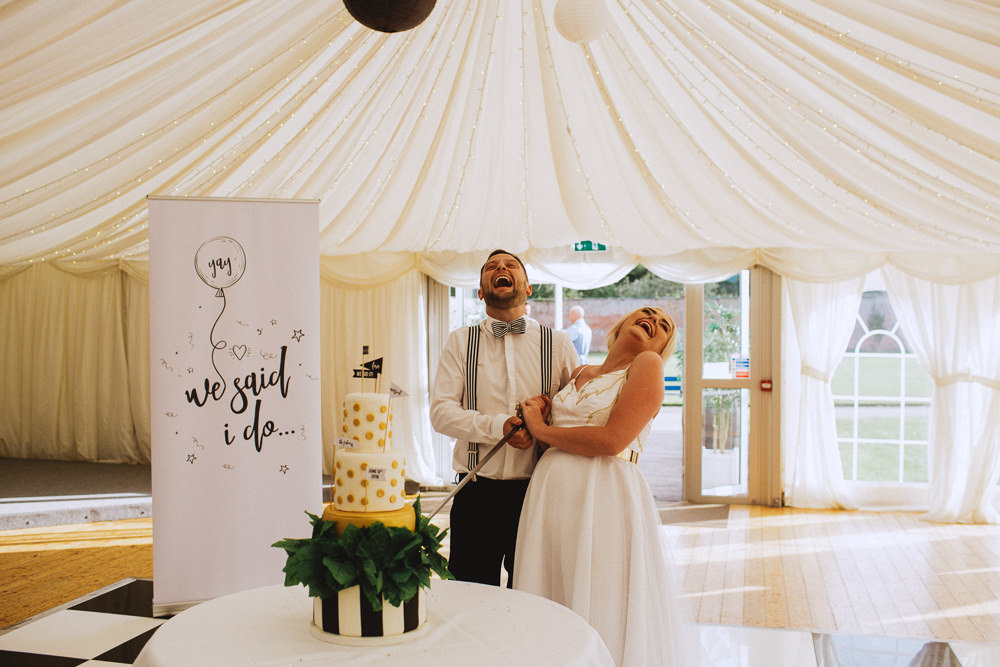 Bride Bridal Dress Strappy Gold Belt Bow Tie Braces Groom Pop Up Banner Modern Calligraphy Cake Cutting Drenagh House Estate Wedding Monochrome Honey and the Moon Photography