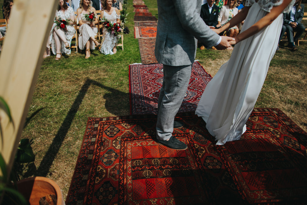 Aisle Ceremony Outdoor Persian Rug Wooden Triangle Backdrop Palm Plants Godwick Great Barn Wedding Joshua Patrick Photography