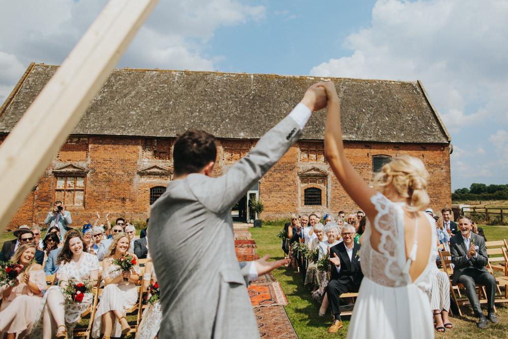 Aisle Ceremony Outdoor Persian Rug Wooden Triangle Backdrop Palm Plants Godwick Great Barn Wedding Joshua Patrick Photography
