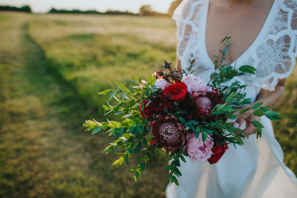 Bouquet Flowers Bride Bridal Red Greenery Foliage Ribbons Peony Peonies Rose Proteas Pink Godwick Great Barn Wedding Joshua Patrick Photography