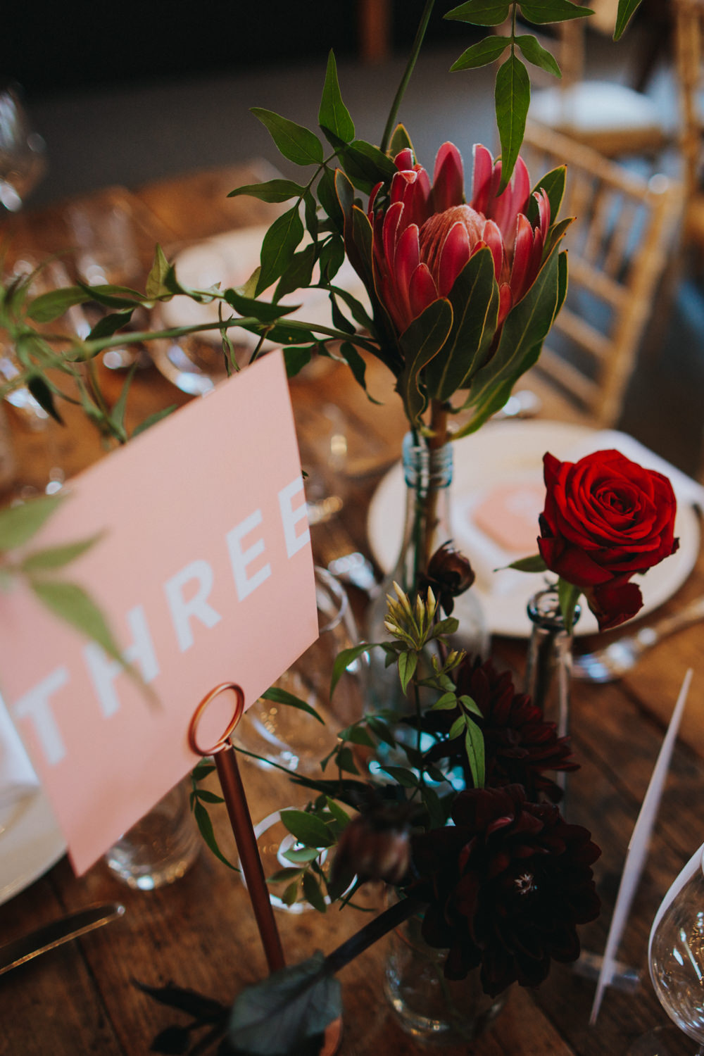 Protea Rose Bottle Copper Red Flowers Pink Graphic Table Names Numbers Godwick Great Barn Wedding Joshua Patrick Photography