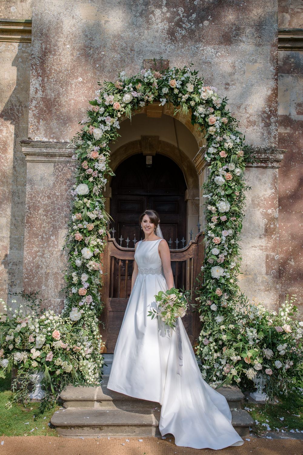 Bride Bridal A Line Dress Straps Sleeveless Silk Boat Neck Veil Entrance Archway Floral Flowers Bouquet Silk Ribbon Babington House Wedding Ria Mishaal Photography