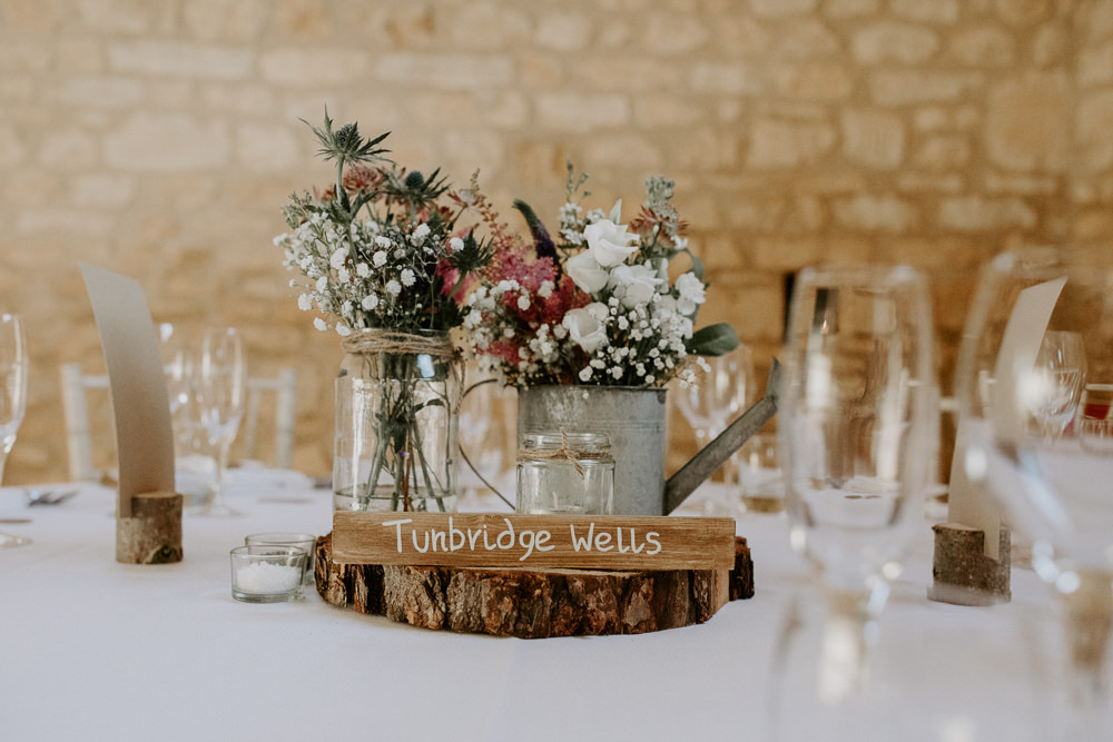 Flowers Watering Can Pink Grenery Thisle Astilbe Centerepice Log Rustic Table Barn Upcote Wedding Siobhan Beales Photography