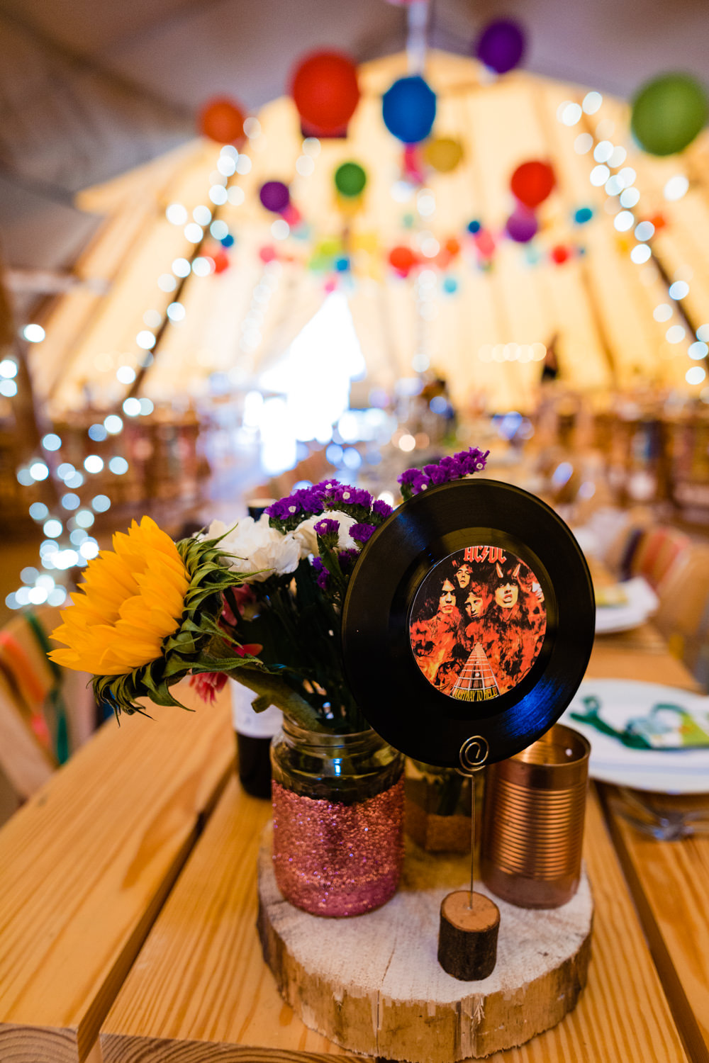 Centrepiece Decor Log Table Tine Jar Flowers Vinyl Table Name Number Colourful Festival Party Wedding Emma and Rich Photography