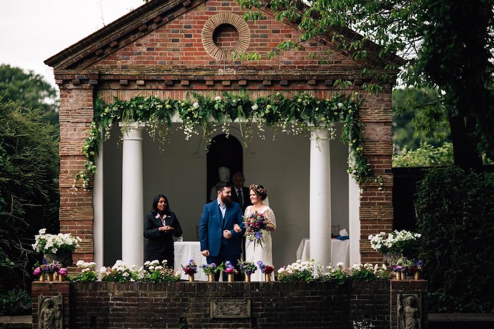 Bride Bridal Dress Gown Lace Sleeves Bodice Train Flower Crown Blue Suit Groom Bouquet Jewel Tone Pink Blue Gold Vases Micklefield Hall Wedding Red On Blonde Photography