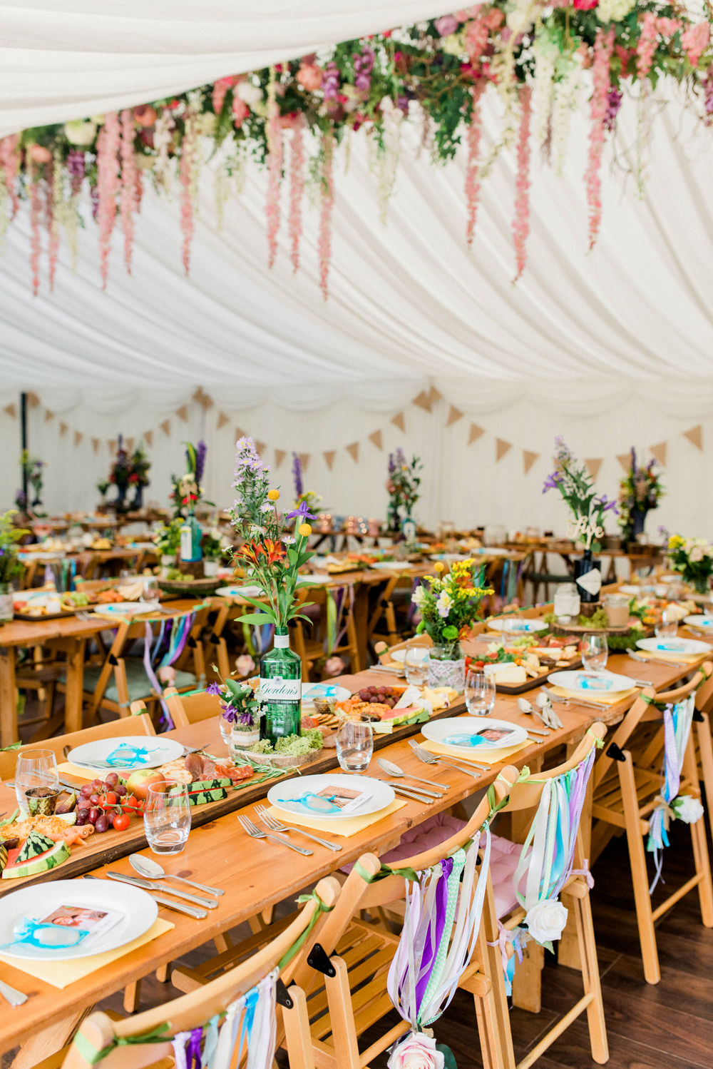 Multicoloured Flowers Floral Hanging Installation Gin Bottles Ribbon Back Chairs Spring Cottage Rivington Wedding Emma B Photography