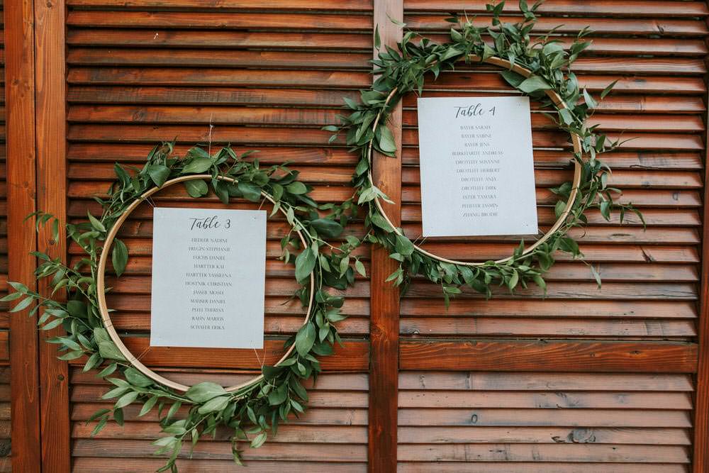 Seating Plan Table Chart Table Botanical Greenery Foliage Wreath Hoop Backdrop Flowers Bohemian Beach Greece Destination Wedding Lighthouse Photography