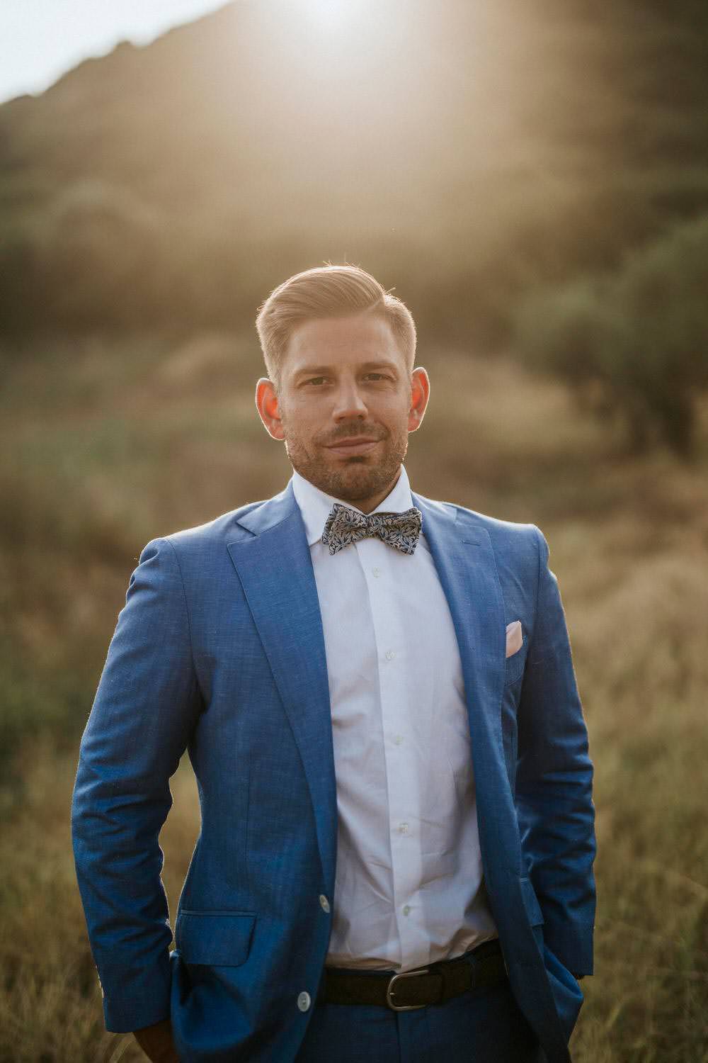 Groom Blue Suit Bow Tie Bohemian Beach Greece Destination Wedding Lighthouse Photography